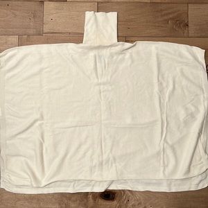 Cream turtle neck poncho with side ties for an adjusted fit in small/medium